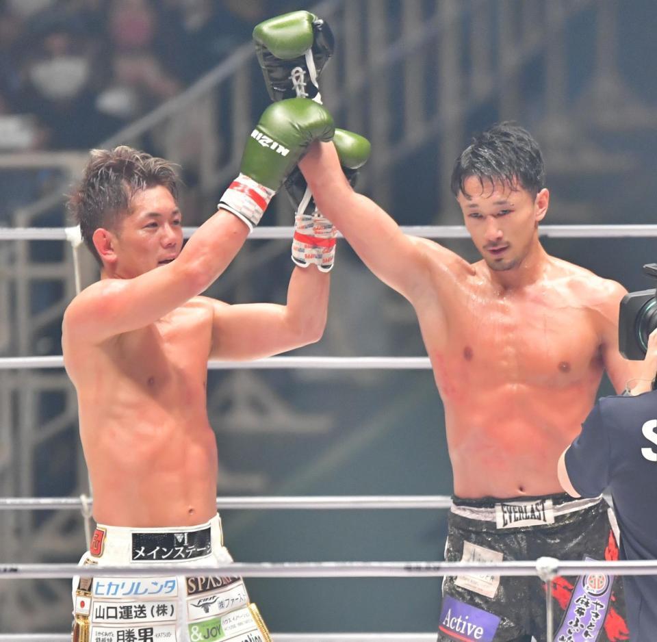 　試合後、判定負けとなった梅野源治（右）の右腕を持ち上げる皇治（撮影・吉澤敬太）