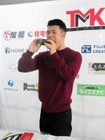 　スポンサーの牛カツ京都勝牛から差し入れられた恵方巻き「勝巻」をほおばる亀田和毅