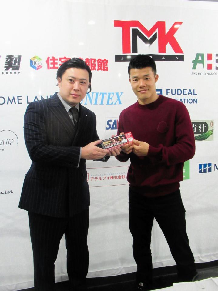 　会議施設に１００万円分のチケットをプレゼントした亀田和毅（右）
