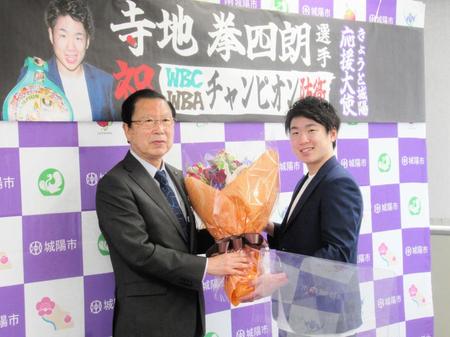 　城陽市を表敬訪問し奥田市長（左）から花束を受け取る拳四朗