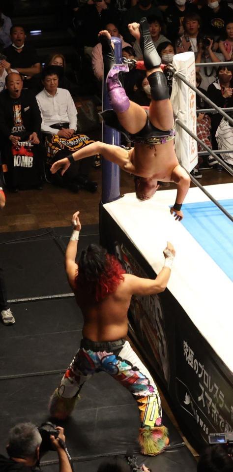 　場外で高橋ヒロム（下）を攻めるマイク・ベイリー