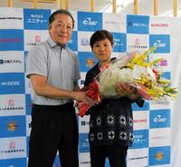 　引退会見で山下正人会長（左）から花束を受ける多田悦子