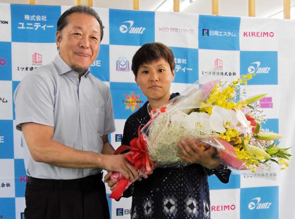 　引退会見で山下正人会長（左）から花束を受ける多田悦子