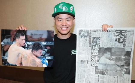 　デイリースポーツと試合の写真を手に笑顔を見せる那須川天心（撮影・吉澤敬太）