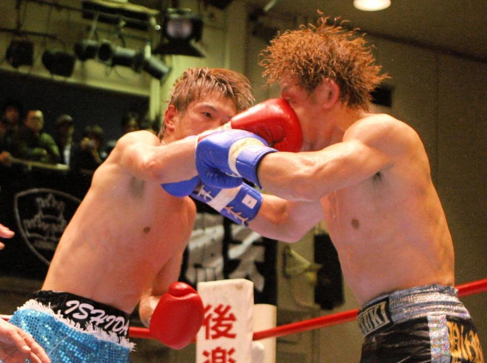 　日本タイトル戦で、６回、石田順裕から右ストレートを浴びる川崎タツキ（右）＝０８年
