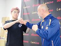 　左肩を負傷した時の状況を中屋廣隆チーフトレーナー（右）を相手に説明する佐々木尽