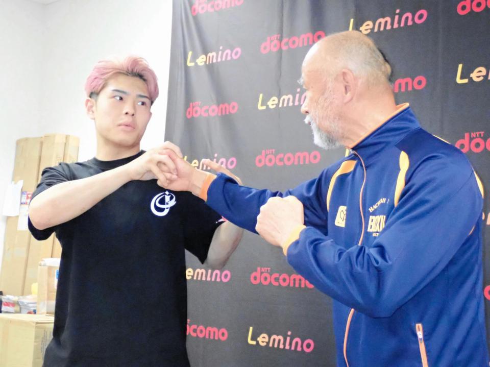 　左肩を負傷した時の状況を中屋廣隆チーフトレーナー（右）を相手に説明する佐々木尽