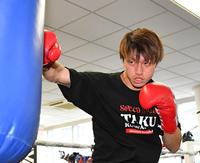 　力のこもったストレートをサンドバッグに打ち込む桑原拓（撮影・持木克友）