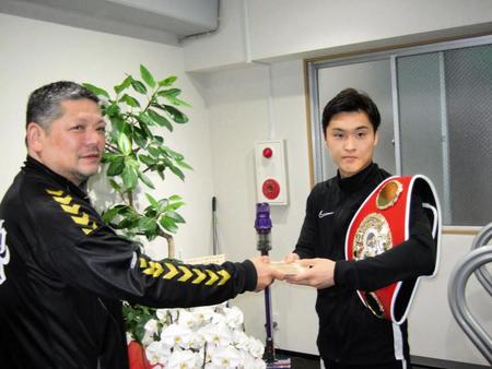 　枝川会長（左）から褒賞金を受け取る西田凌佑