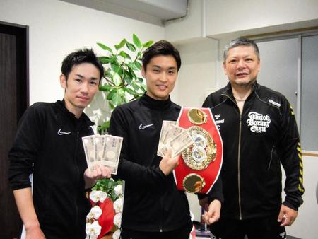 　褒賞金を手に笑顔の西田凌佑（中）、右は枝川会長、左は武市トレーナー