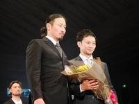 　麻原将平（右）の引退セレモニーで花束を贈呈したＴＯＭＯ（森知行）氏