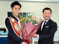 　名城信男・近大ボクシング部監督（右）から花束を贈られ笑顔の西田凌佑