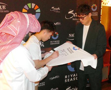 　「リヤド・シーズン」のＴシャツにサインを入れる井上尚弥