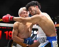 　よしきまる（手前）にパンチを出す冨澤大智（撮影・堀内翔）
