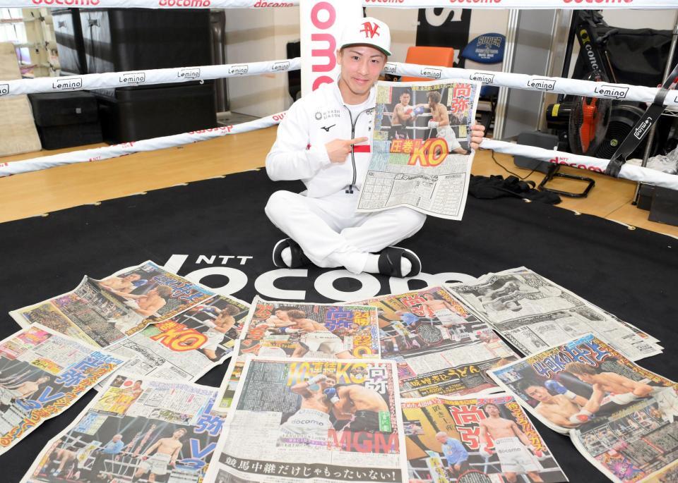 王座防衛戦から一夜明け、デイリースポーツを手に笑顔を見せる井上尚弥＝横浜・大橋ジム（撮影・伊藤笙子）