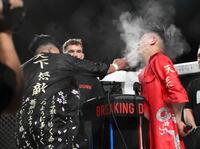 　シェンロン（左）からの平手打を受けるレオ＝２５日