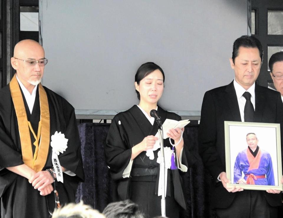 　西村修さんの葬儀で喪主あいさつをする妻の恵さん（中央）。左は葬儀委員長を務めた新日本プロレストレーナーの三沢威さん