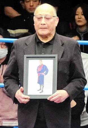 　西村修さんの写真を持ちリングに立った渕正信