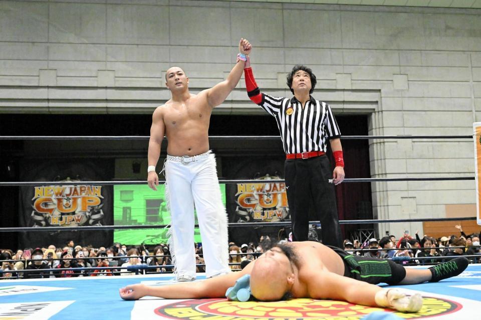 　オーカーン（手前）に雪辱し、父でもあるレッドシューズ海野（右）から勝ち名乗りを受ける海野翔太＝新日本プロレス提供
