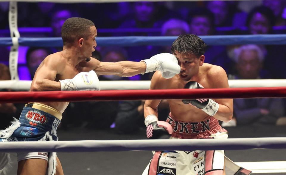 　１２回、レネ・サンティアゴの左ストレートを浴びる岩田翔吉（撮影・佐々木彰尚）