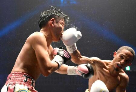 　１２回、サンティアゴ（右）のパンチを浴びる岩田翔吉（撮影・堀内翔）