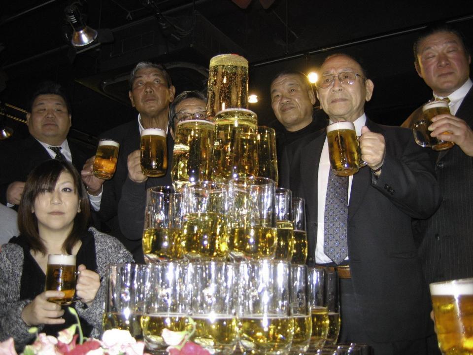　乾杯する新間さん（右から２人目）。後列左から若翔洋、坂口氏、グラン浜田、藤原喜明、（新間氏を挟んで）木村健悟氏、前列左はＫＡＯＲＵ＝２０１１年３月撮影