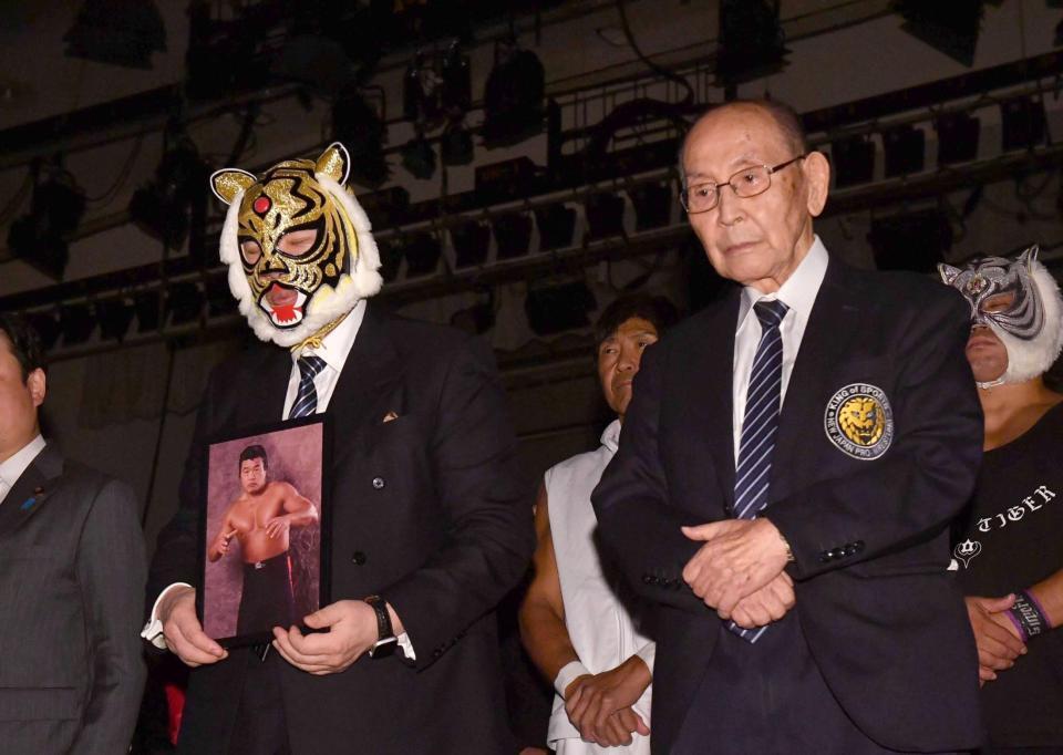 故・小林邦昭さん追悼式で遺影を手にする初代タイガーマスクの佐山聡（左）。出席した新間寿会長＝２０２４年９月