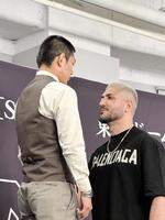 　椅子の上に立ってフェイスオフする皇治（左）とカリミアン