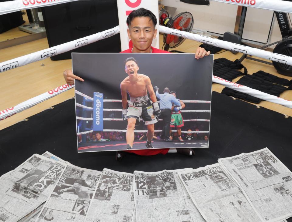 　ＴＫＯ勝利時のデイリースポーツの写真を手に笑顔を見せる武居由樹（撮影・吉澤敬太）