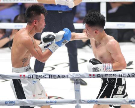 　１０回、バン・タオ・トラン（左）に右フックを浴びせる坪井智也（撮影・西岡正）