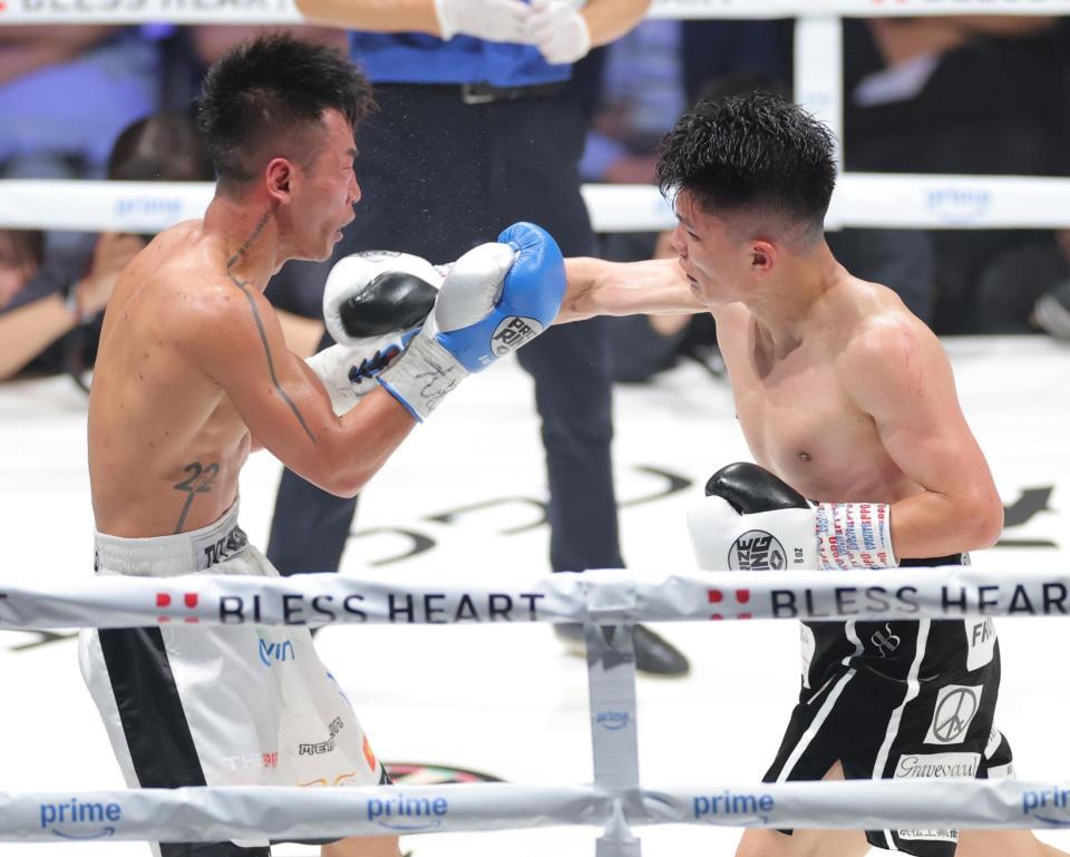 　１０回、バン・タオ・トラン（左）に右フックを浴びせる坪井智也（撮影・西岡正）