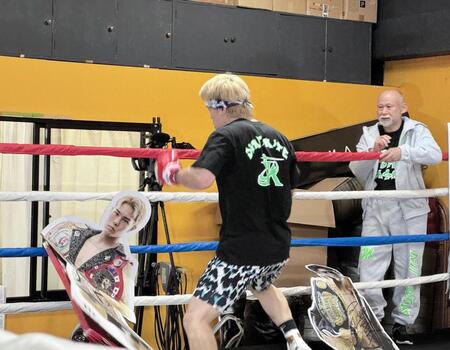 　「過去の自分とスパーリングする」と宣言し、自身の等身大パネルをボコボコにする佐々木尽。右は中屋広隆チーフトレーナー