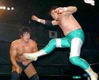 　ジャンピングキックを小橋に放つ三沢（右）