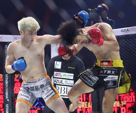 　よしきまる（右）と激しい攻防を見せる竹見浩史郎＝１３日