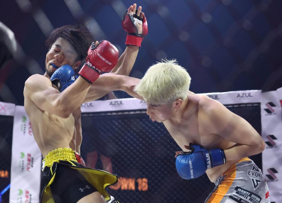 　よしきまる（左）に右ストレートを打ち込む竹見浩史郎＝１３日