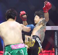 　アマリザ（左）に膝蹴りを見舞う啓之輔＝１２日