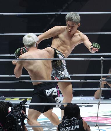 　赤田功輝（左）に強烈なキックを見舞う秋元強真