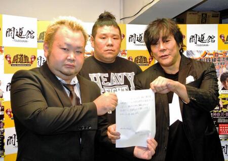 　橋本友彦さん（中）の立ち会いの下で誓約書を披露する大仁田厚（右）とハチミツ二郎＝２０１７年