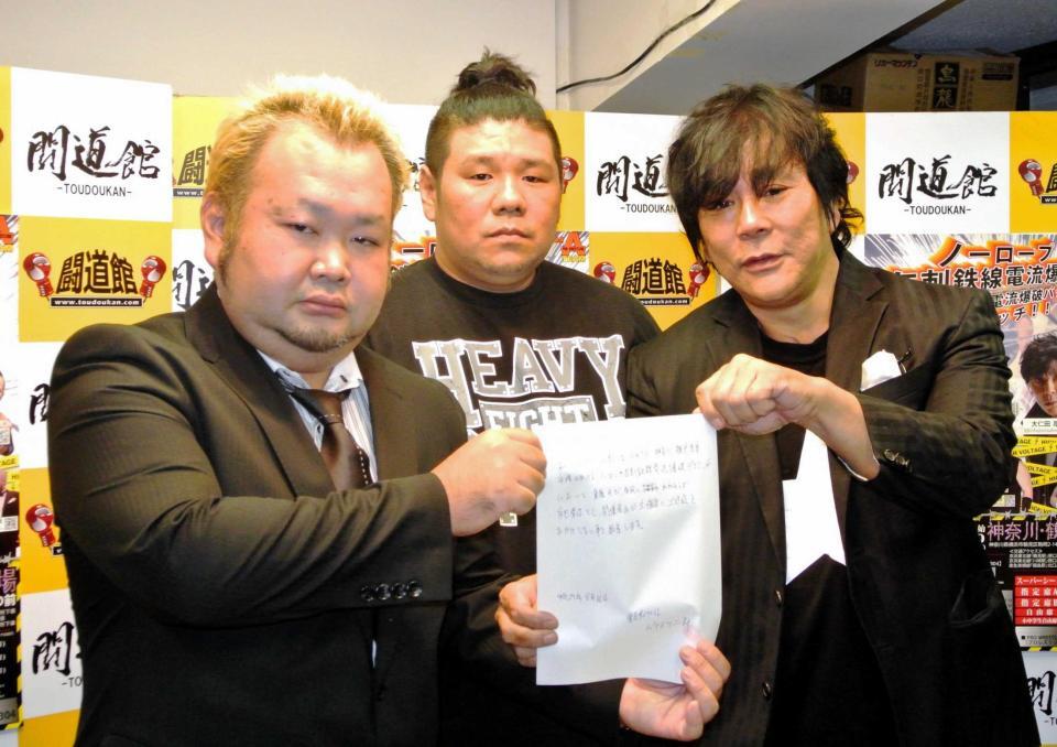 　橋本友彦さん（中）の立ち会いの下で誓約書を披露する大仁田厚（右）とハチミツ二郎＝２０１７年