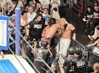 　目の前で繰り広げられた場外乱闘を見守るセコンドのウルフ・アロン（左）