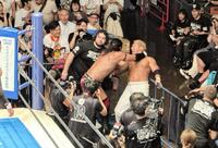 　目の前で繰り広げられた場外乱闘を見守るセコンドのウルフ・アロン（左）