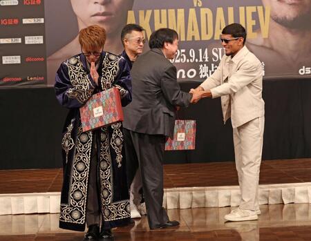 　ムロジョン・アフマダリエフ（右）からチャパンをプレゼントされ、両手を合わせる井上尚弥（撮影・中田匡峻）