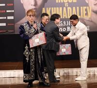 　ムロジョン・アフマダリエフ（右）からチャパンをプレゼントされ、両手を合わせる井上尚弥（撮影・中田匡峻）