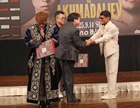 　ムロジョン・アフマダリエフ（右）からチャパンをプレゼントされ、両手を合わせる井上尚弥（撮影・中田匡峻）