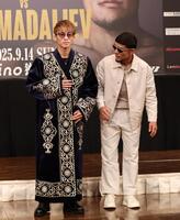 　ムロジョン・アフマダリエフ（右）からプレゼントされたチャパンを着用する井上尚弥（撮影・中田匡峻）