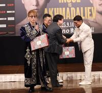 　ムロジョン・アフマダリエフ（右）からチャパンをプレゼントされ、両手を合わせる井上尚弥（撮影・中田匡峻）