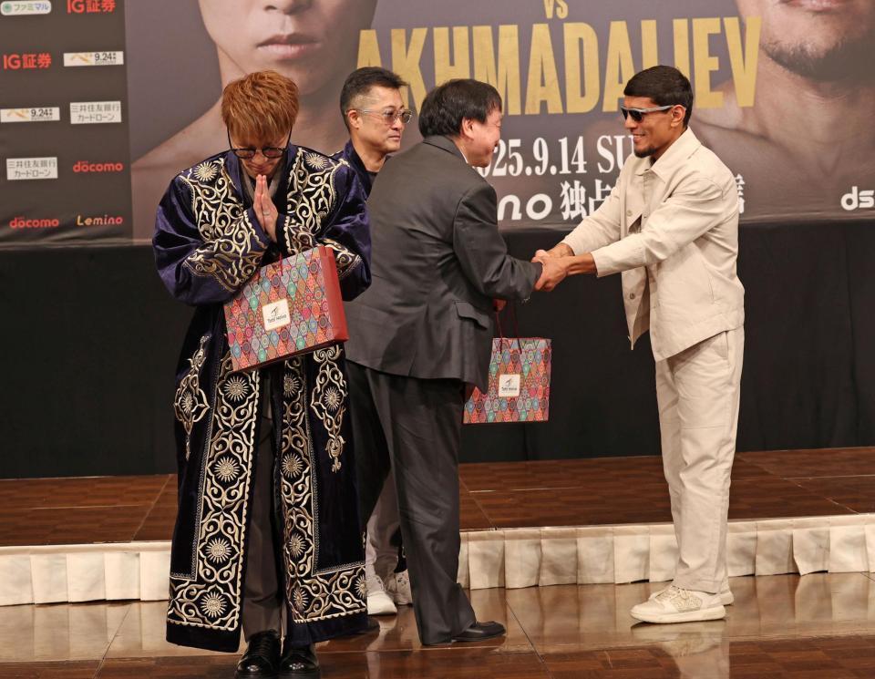 　ムロジョン・アフマダリエフ（右）からチャパンをプレゼントされ、両手を合わせる井上尚弥（撮影・中田匡峻）