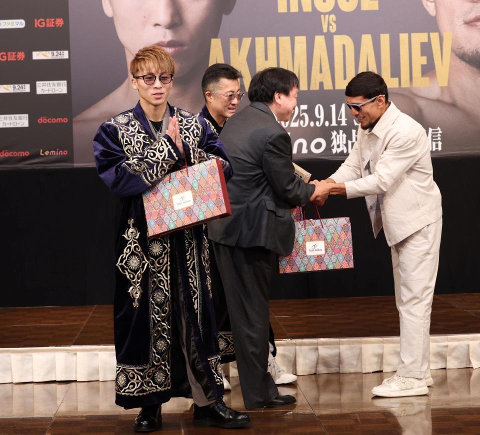 　ムロジョン・アフマダリエフ（右）からチャパンをプレゼントされ、両手を合わせる井上尚弥（撮影・中田匡峻）