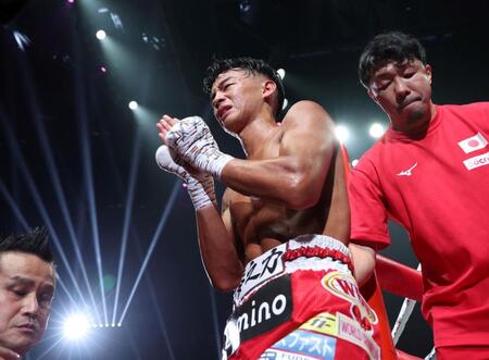 　クリスチャン・メディナにＴＫＯ負けを喫し、両手を合わせながらリングを降りる武居由樹。右は八重樫東トレーナー（撮影・中田匡峻）