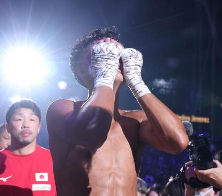 　クリスチャン・メディナに敗れ、顔を覆いながら引き揚げる武居由樹。奥は八重樫東トレーナー（撮影・中田匡峻）